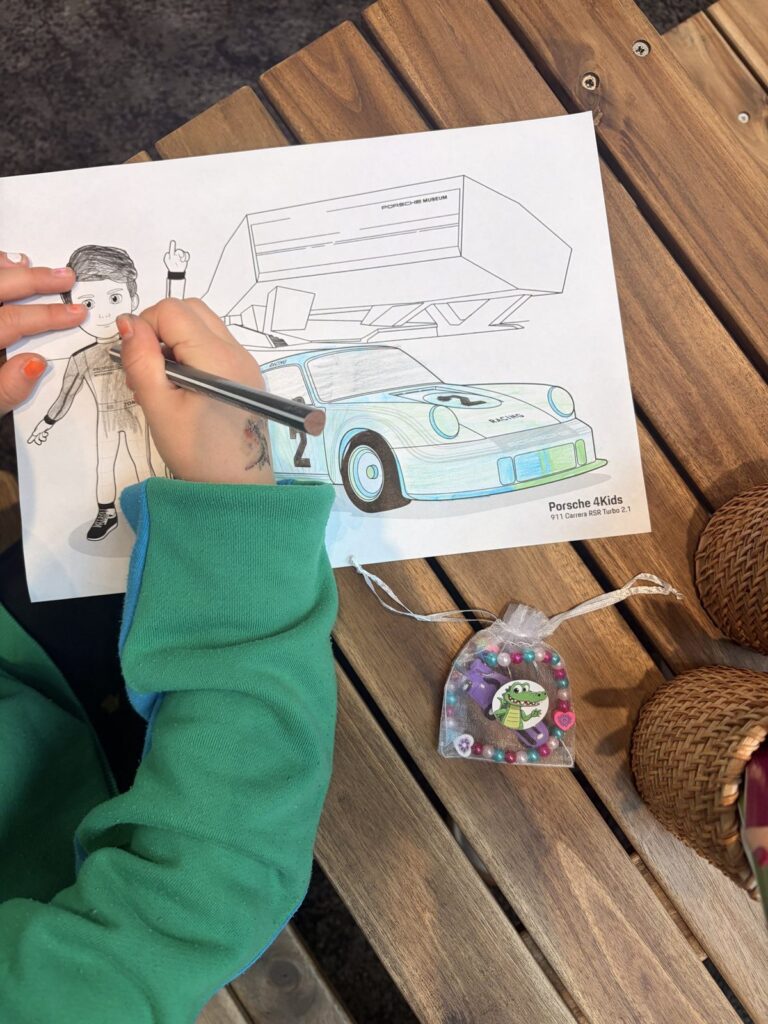 Kind malt ein Porsche-Ausmalbild in der Kids-Zone